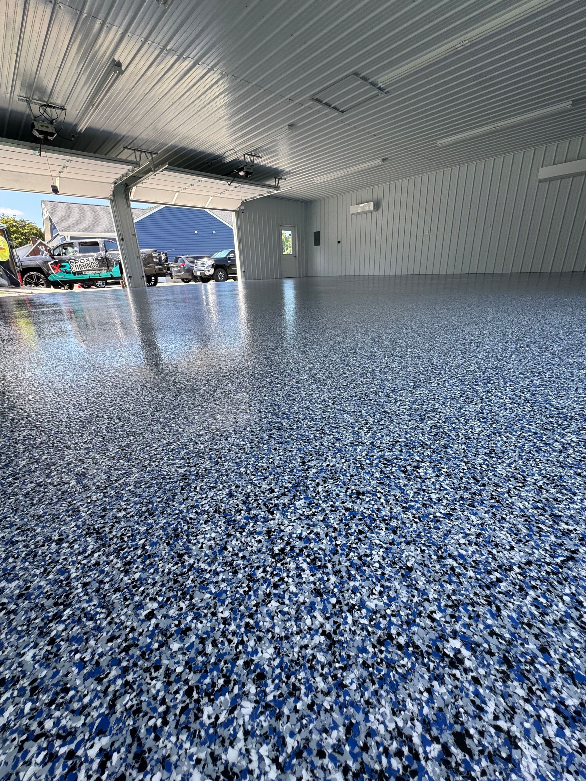 Modern building interior with a blue speckled floor and a bright, open entrance to the outside