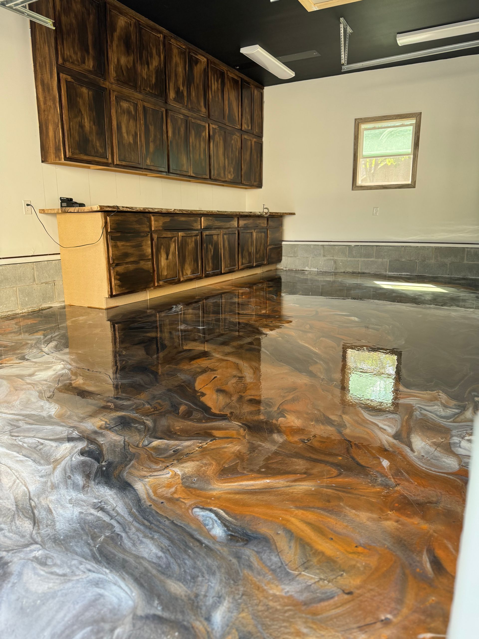 Empty room with glossy marbled epoxy floor and rustic wood cabinet against beige walls.