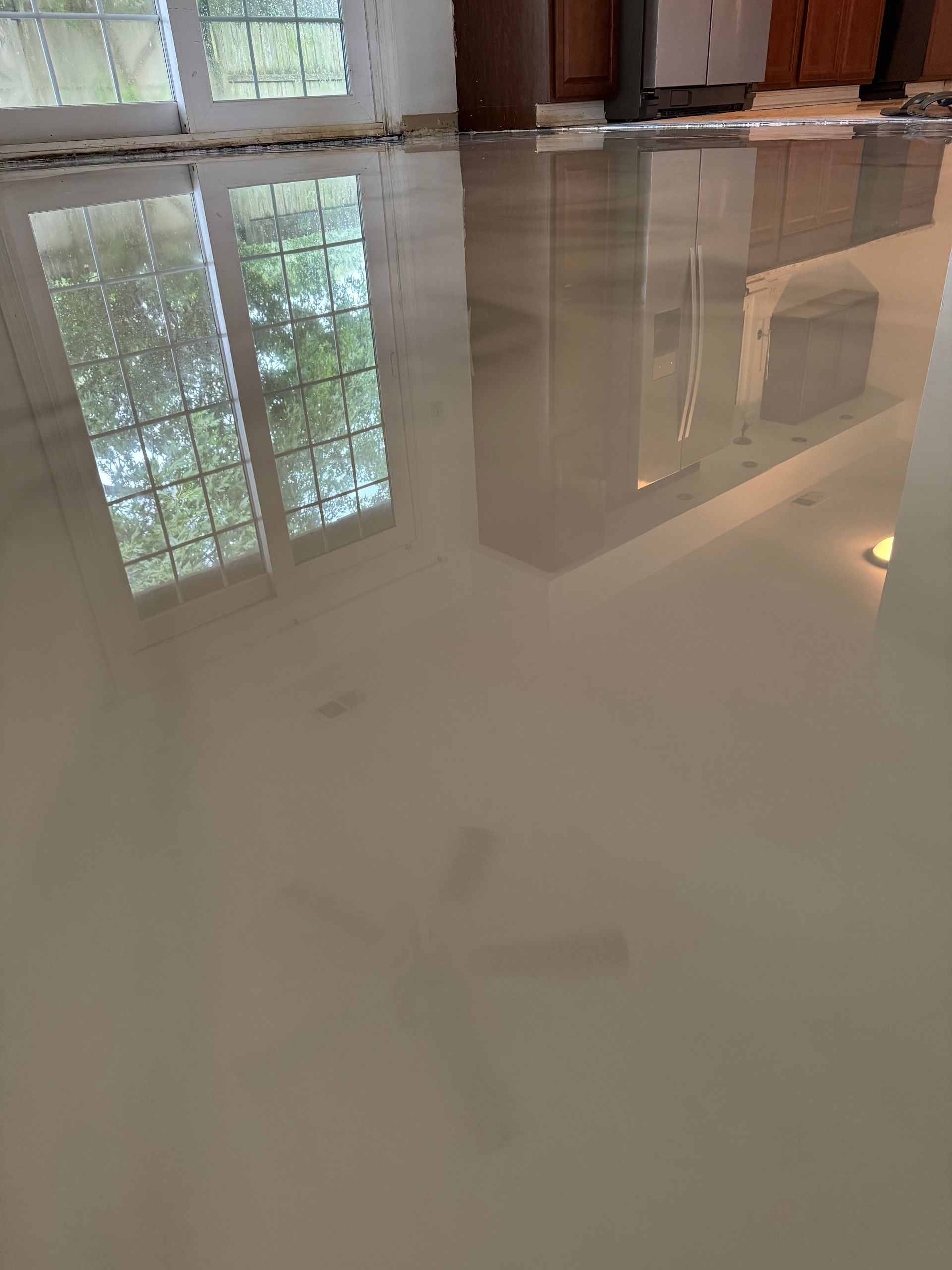 Polished indoor floor reflecting windows and walls in a bright room