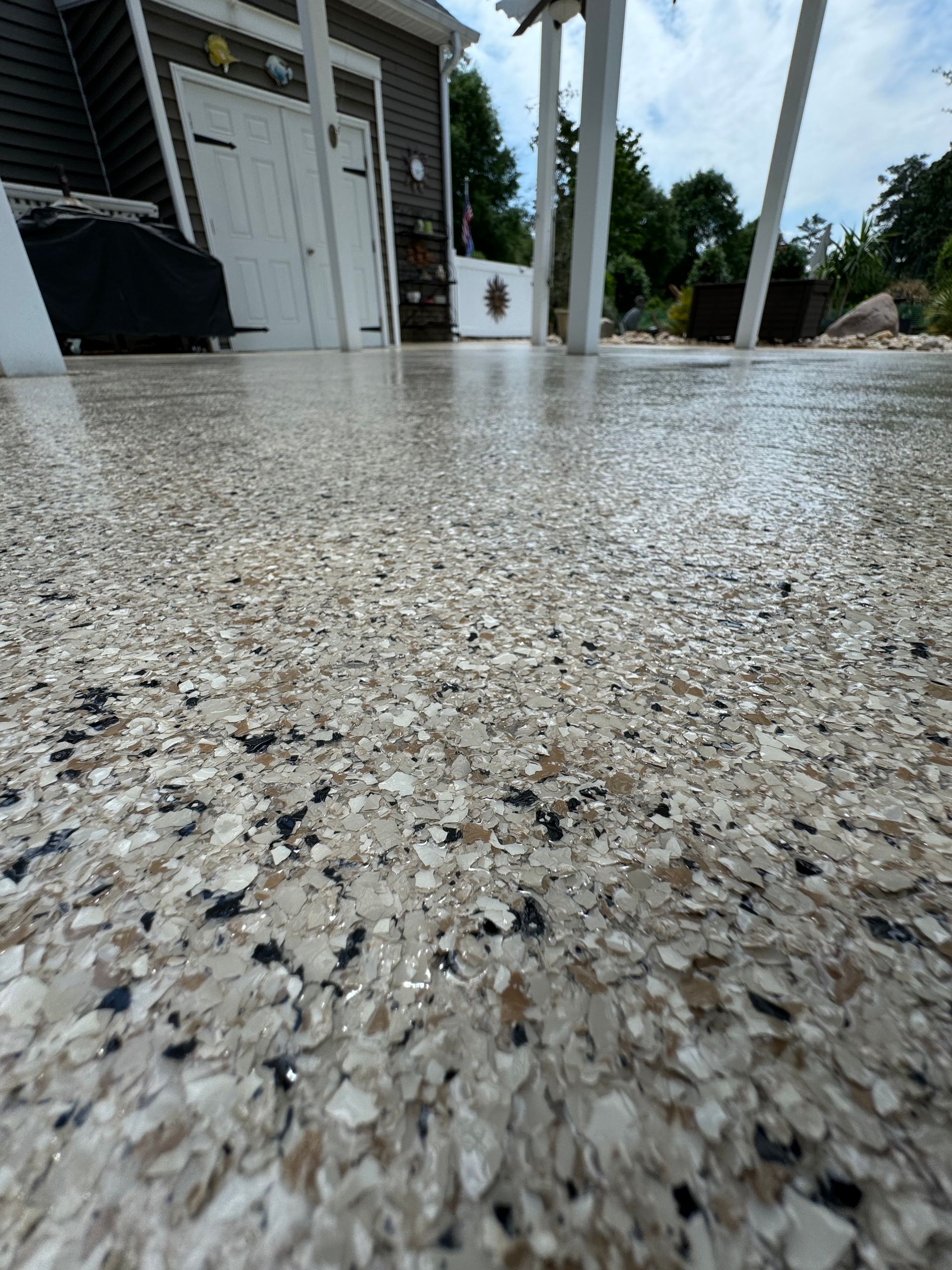 Low-angle view of a wet, speckled patio beside a house after rain