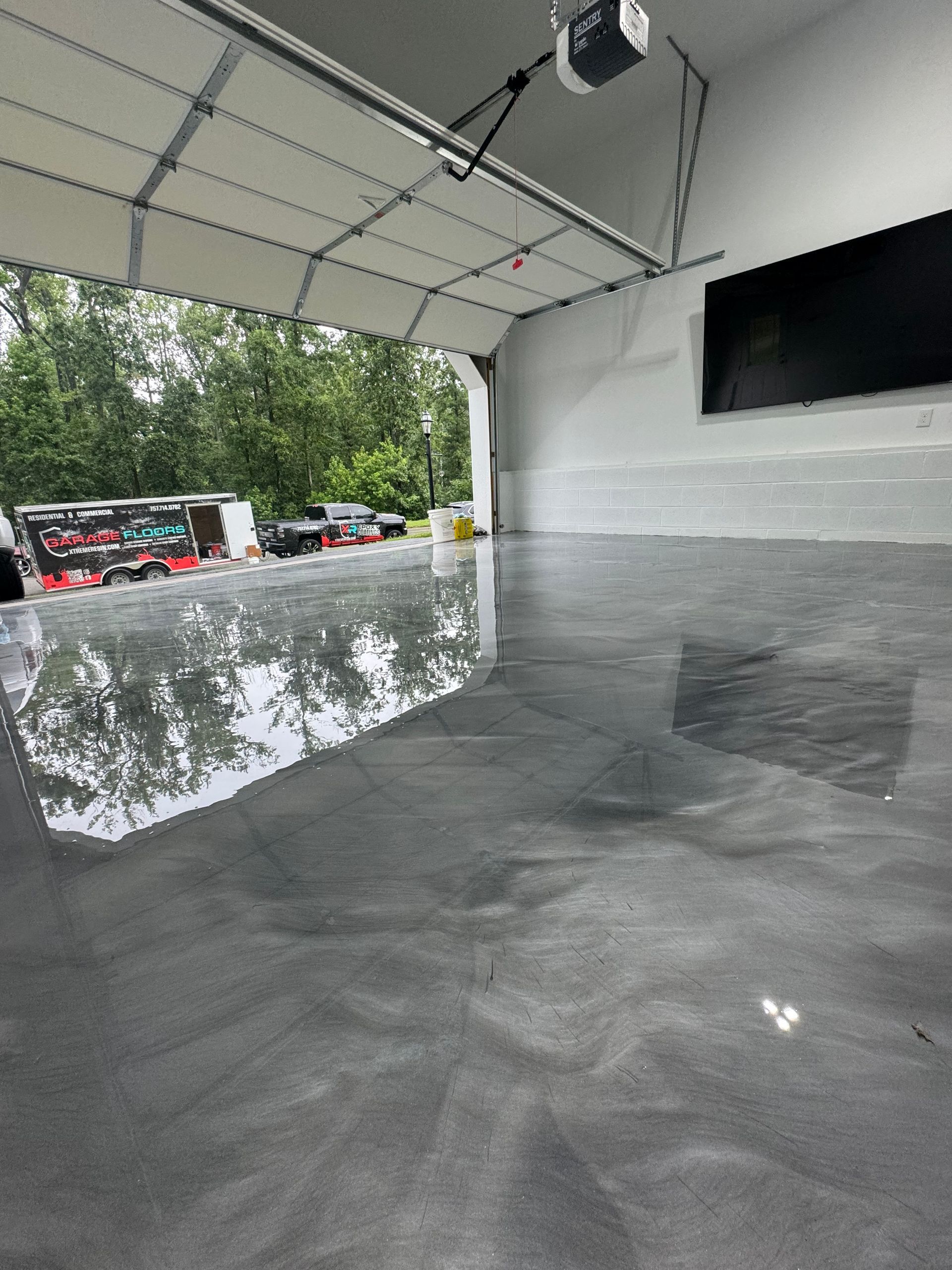 Empty indoor-outdoor event space with polished concrete floor, white canopy, and clear barrier walls