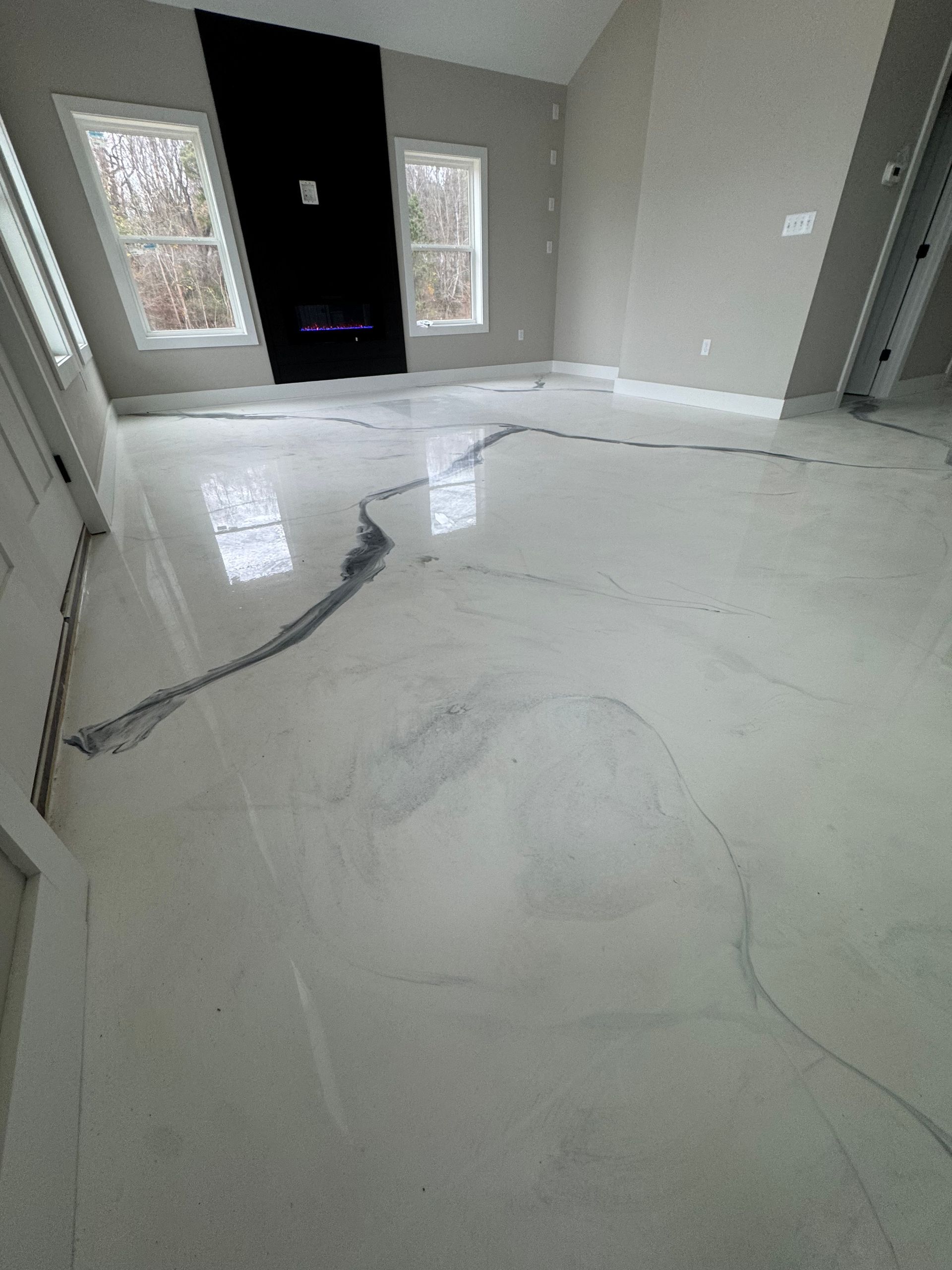 Interior room with glossy white floor tiles and large visible cracks near a front doorway.