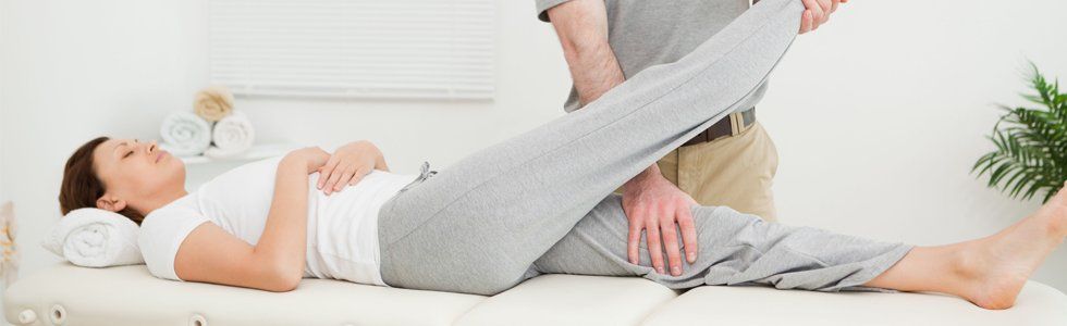 chiropractor massaging patient's legs