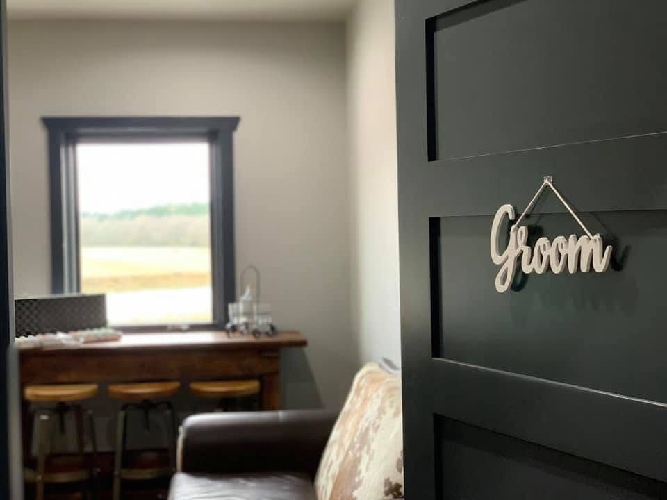 Home office with desk by a window and a black door signed “Farm”