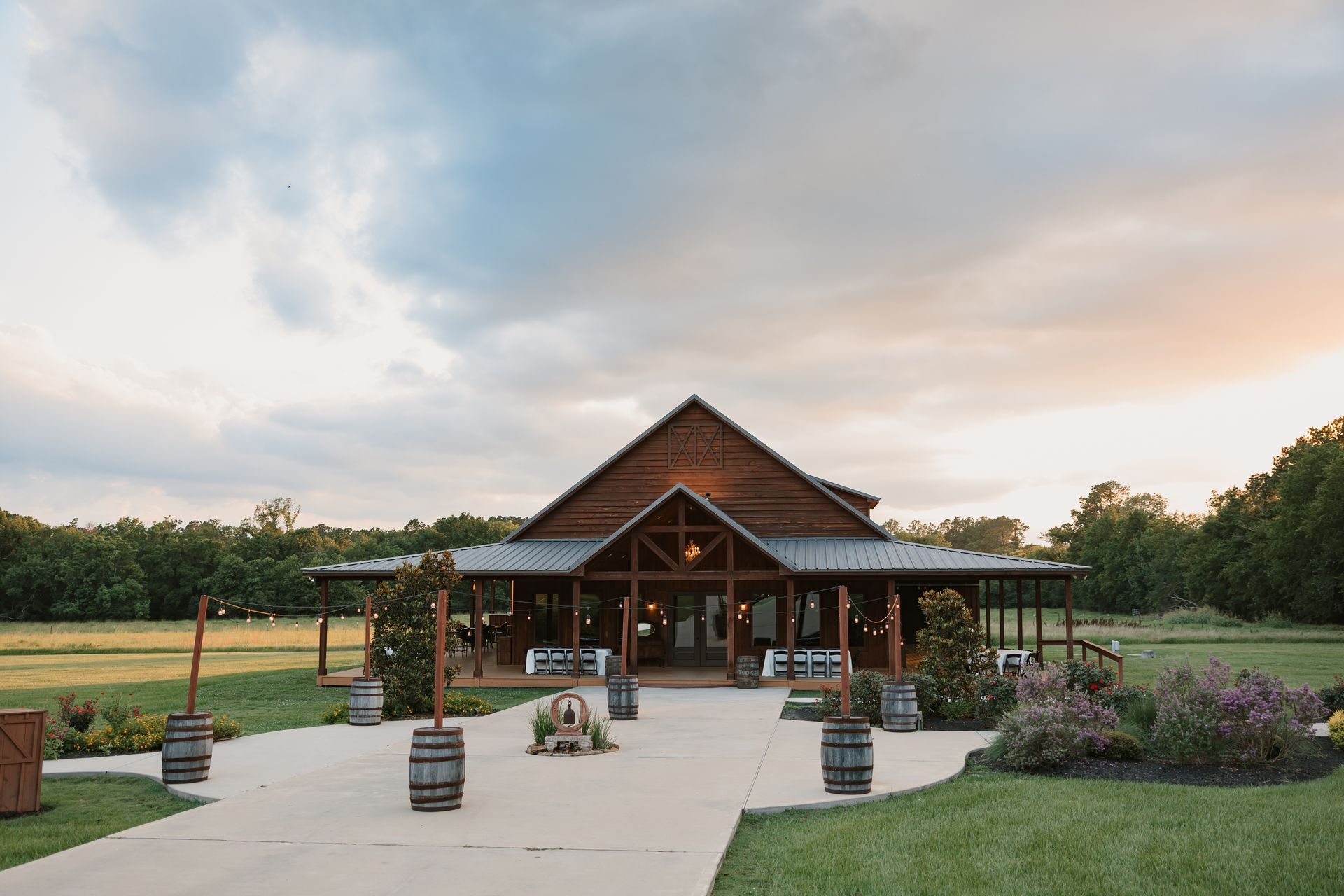 Lodge-style building with a covered entrance at dusk, set among lawns and trees