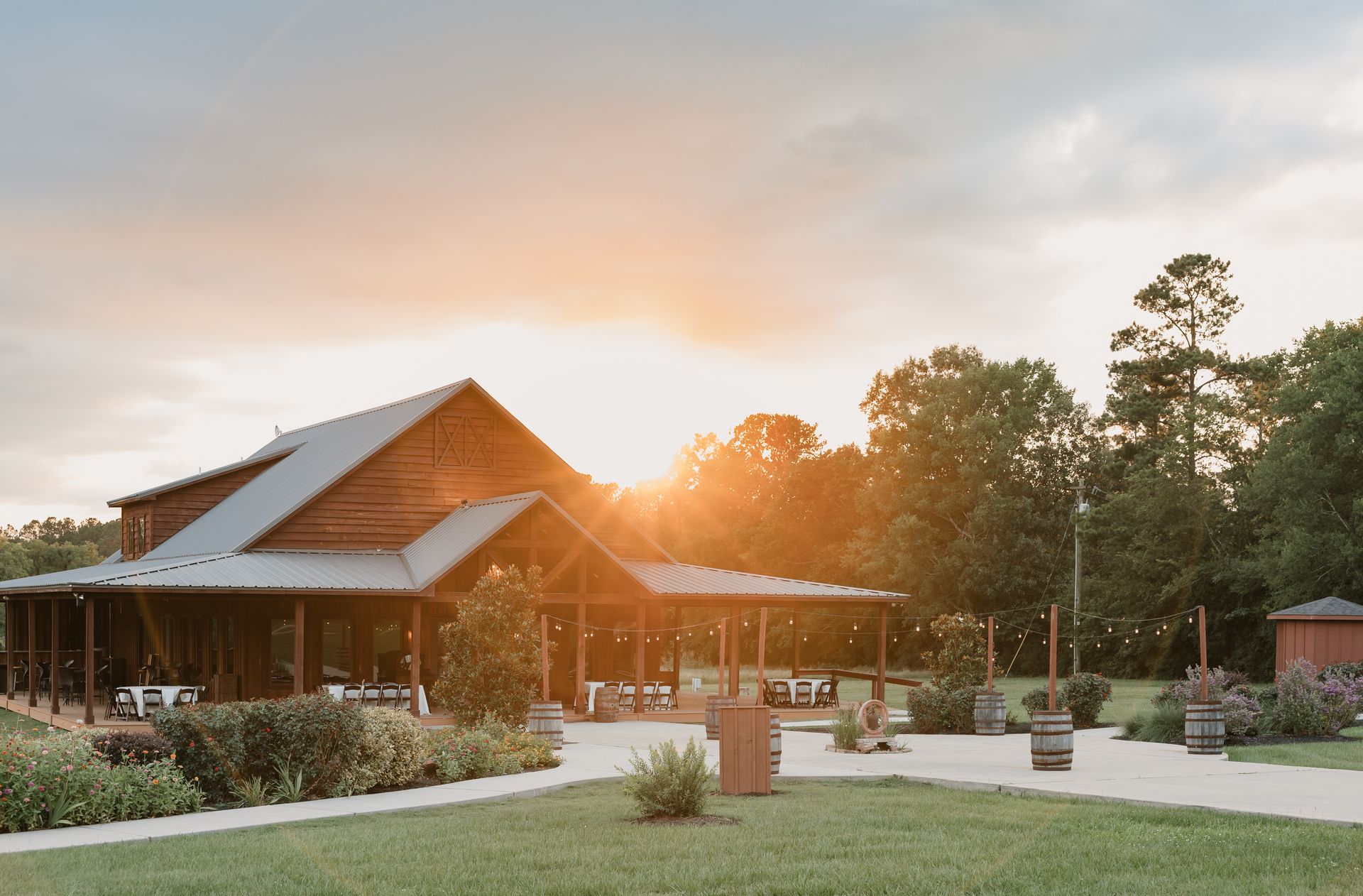 Sunlit rustic lodge with a covered porch and garden path at sunset