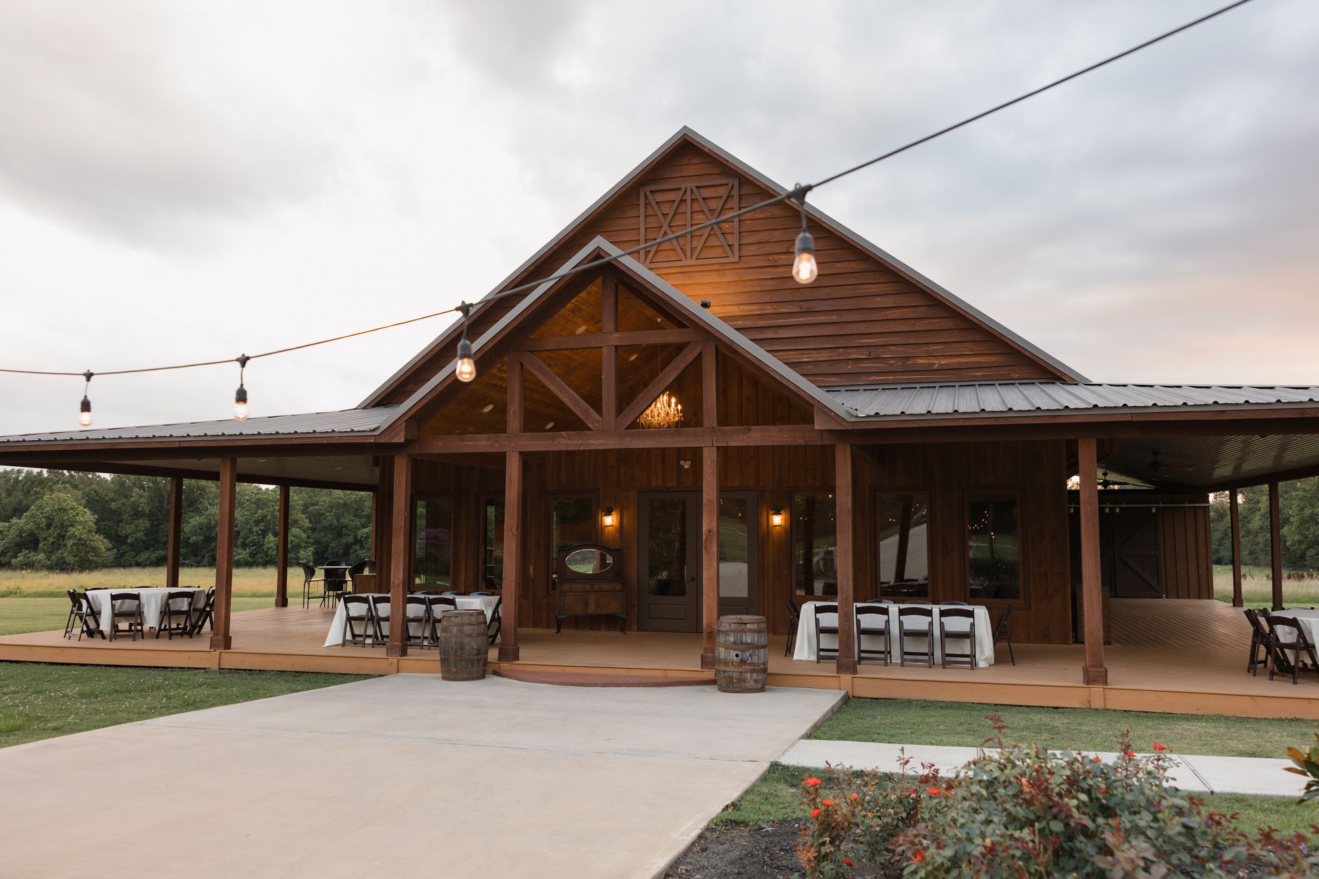 Rustic wooden lodge with a covered porch and outdoor seating at sunset