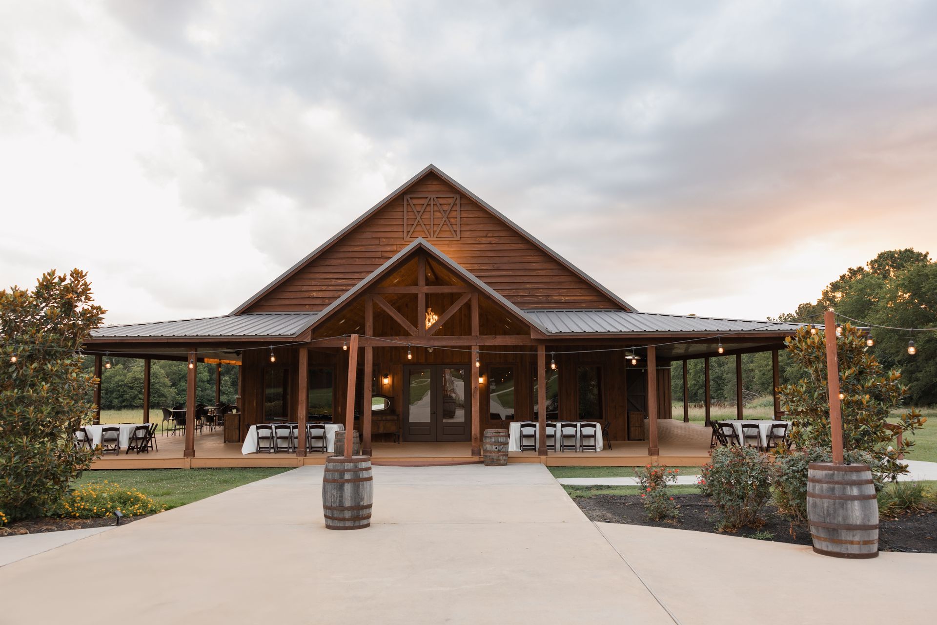 Rustic lodge entrance with a gabled wooden facade, covered porch, and paved walkway at sunset