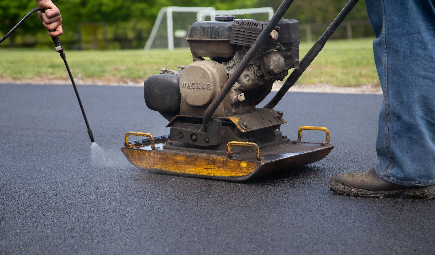 A person is using a machine to clean the asphalt.