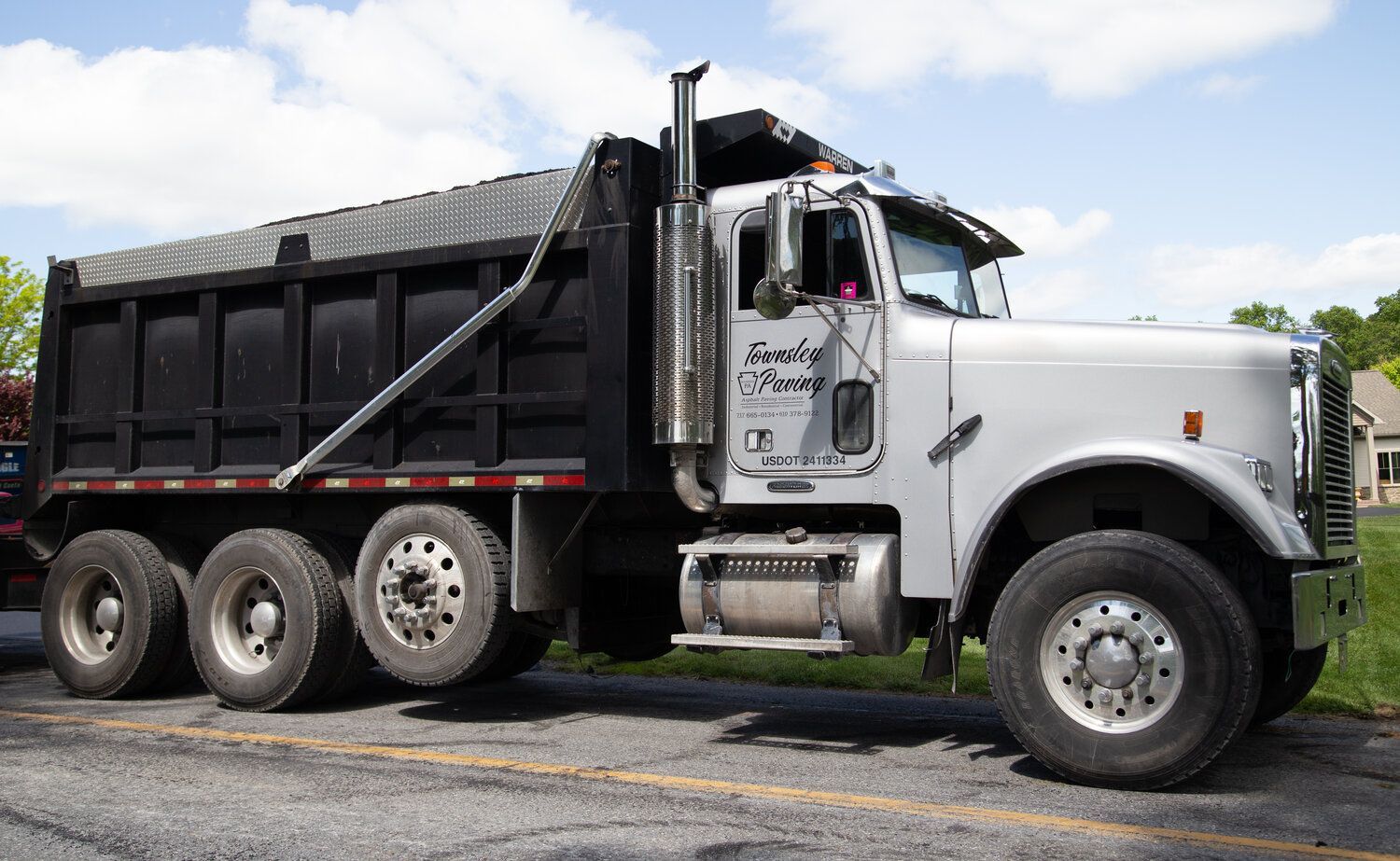 A dump truck is parked on the side of the road.