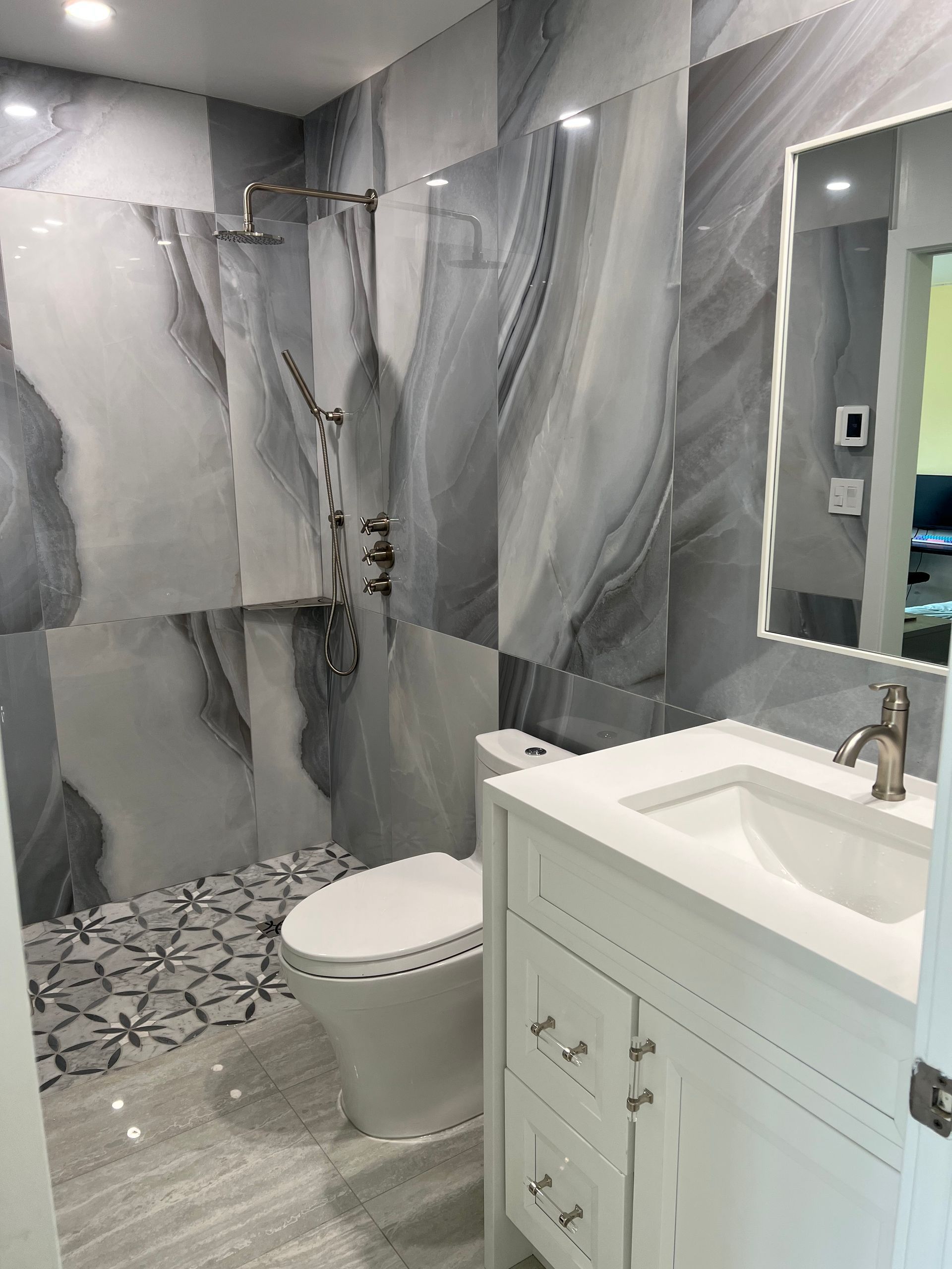 A bathroom with a toilet, sink, and shower.