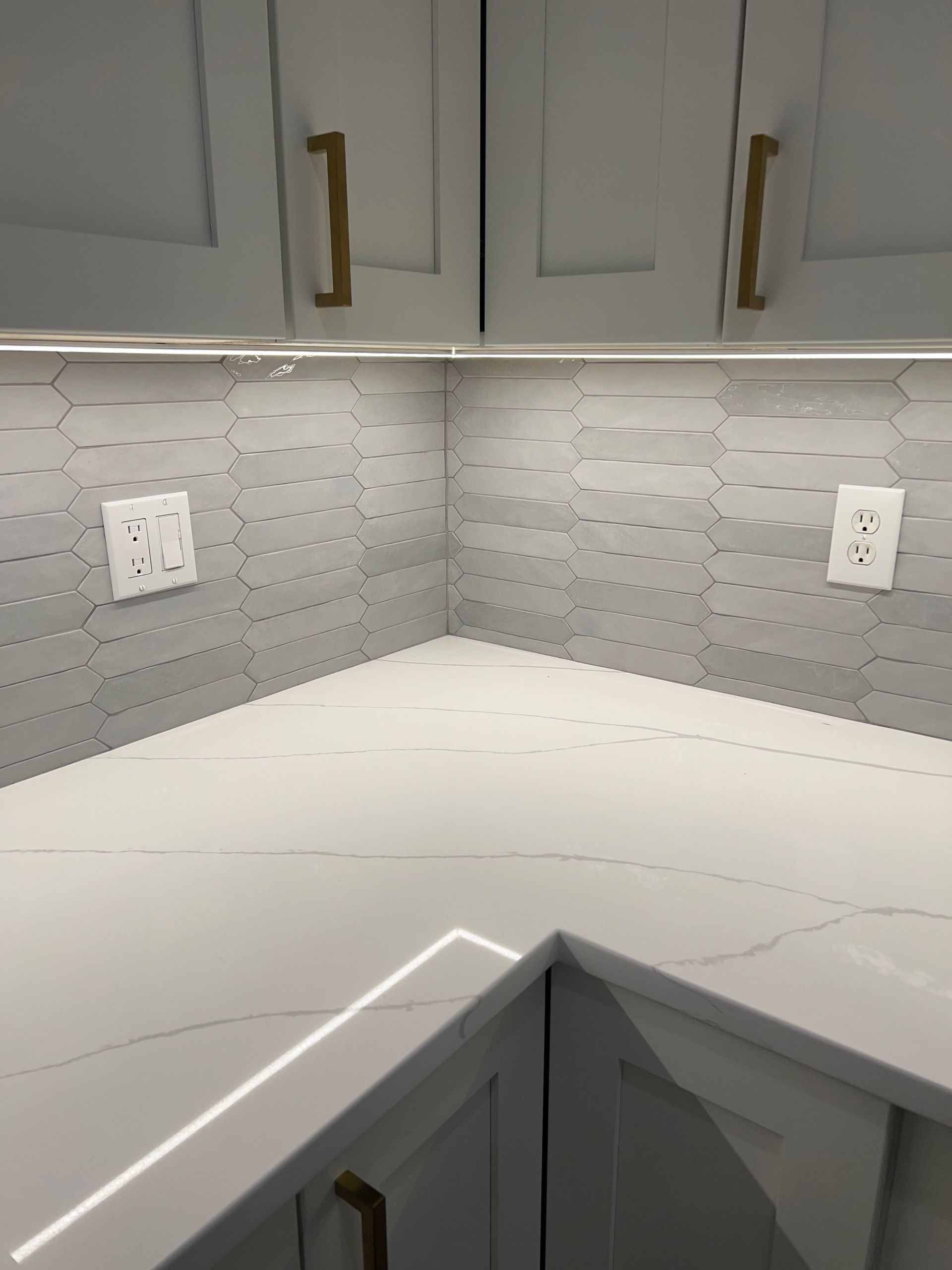 A kitchen with white cabinets and a white counter top.