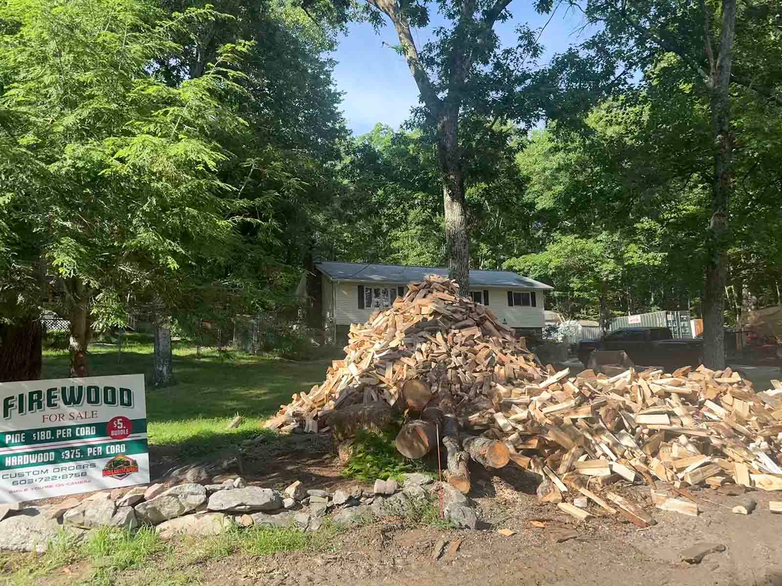 Large pile of wood chips beside a Fairwood sign and trees in a wooded yard