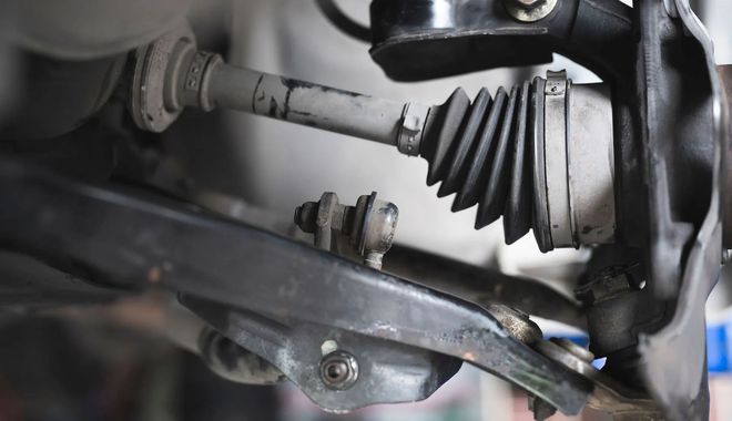 Car axle and suspension components, close-up. Black and gray metal parts.
