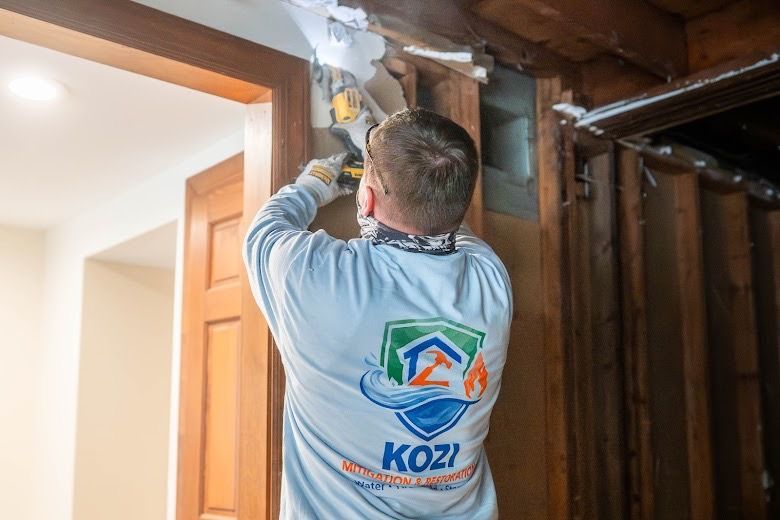 Worker installing insulation above a doorway in a home interior