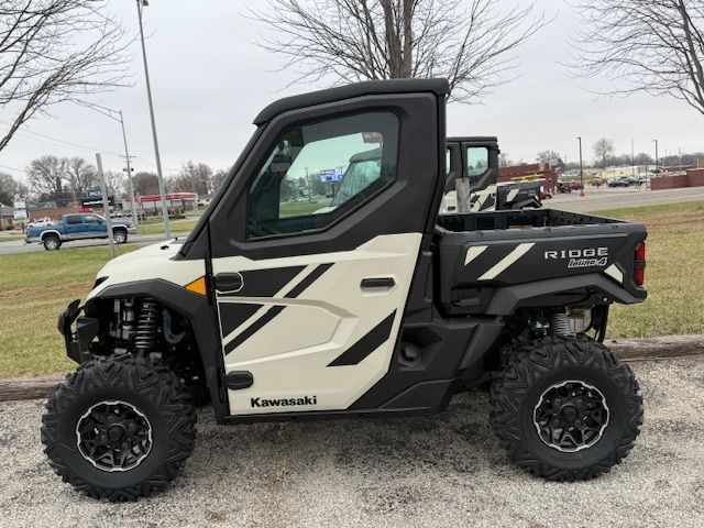 Black and white Kawasaki side-by-side ATV parked outdoors on a cloudy day