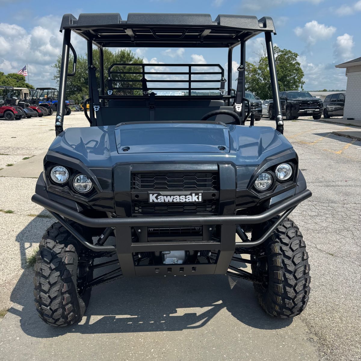 Front view of a black Kawasaki side-by-side off-road vehicle parked outdoors.