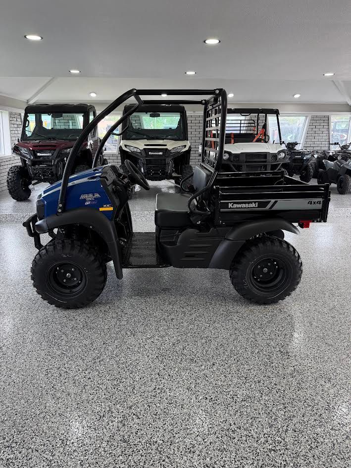 Blue and black utility side-by-side ATV in a showroom with other off-road vehicles behind it