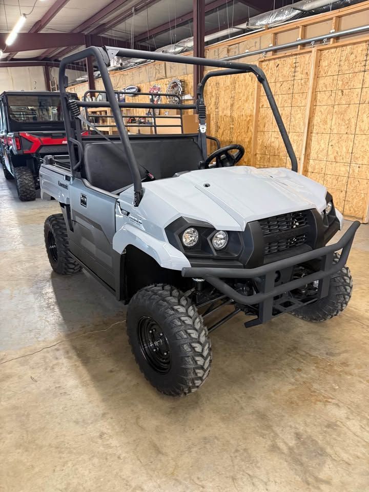 Gray off-road UTV parked indoors in a garage, with black roll cage and large tires