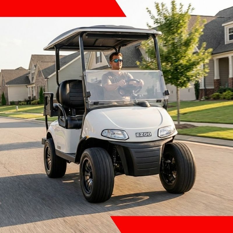White golf cart driving on a suburban street, with a driver wearing sunglasses.