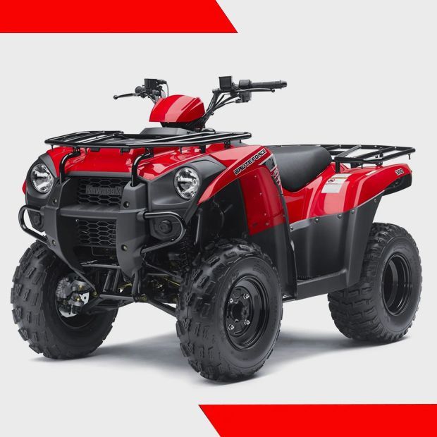 Red sport ATV on grass with a white trailer and hills in the background