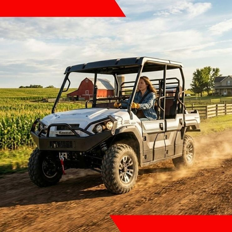 Off-road utility vehicle driving on a dirt road beside green fields, kicking up dust