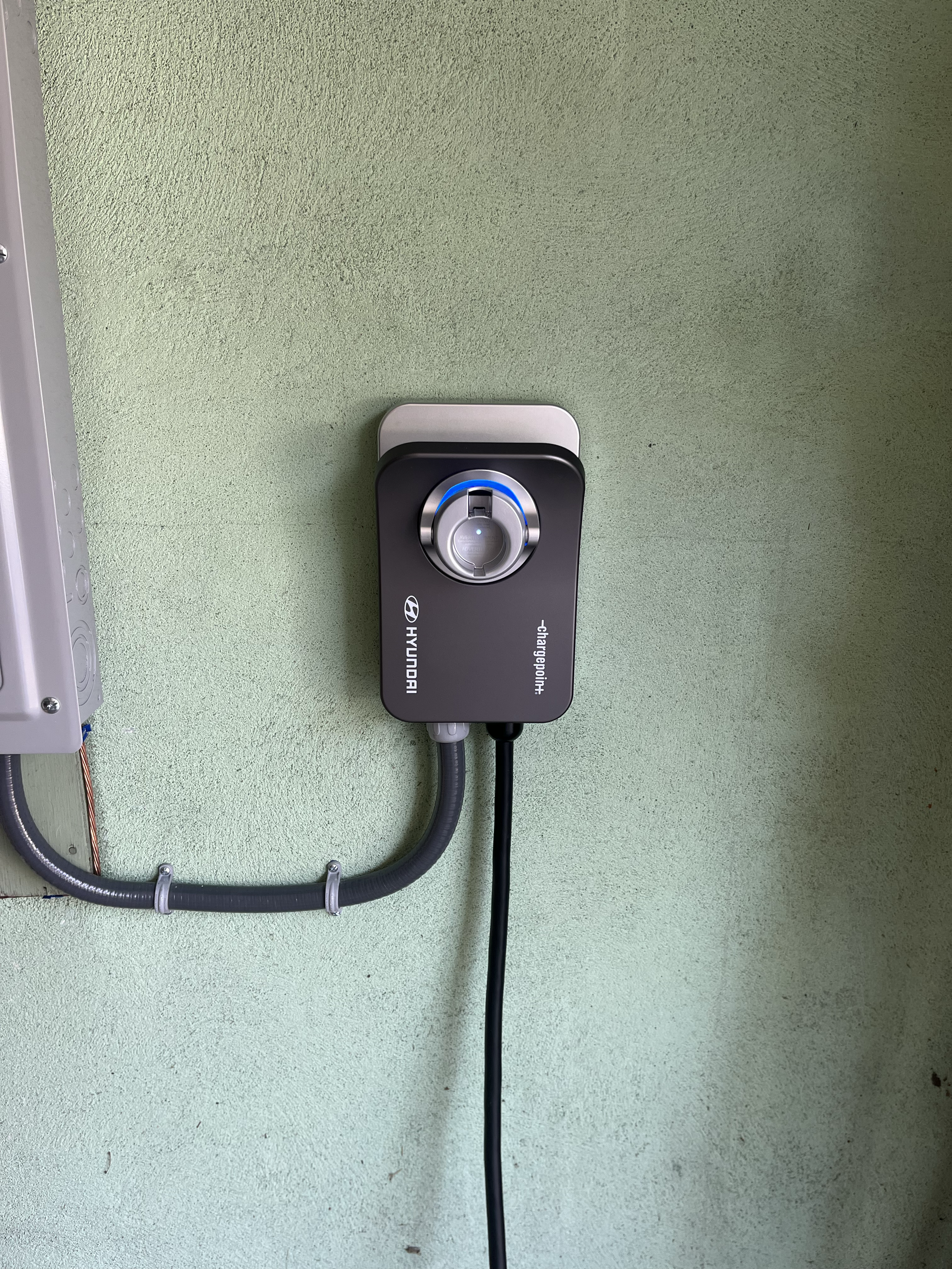 A black timer is attached to a green wall.