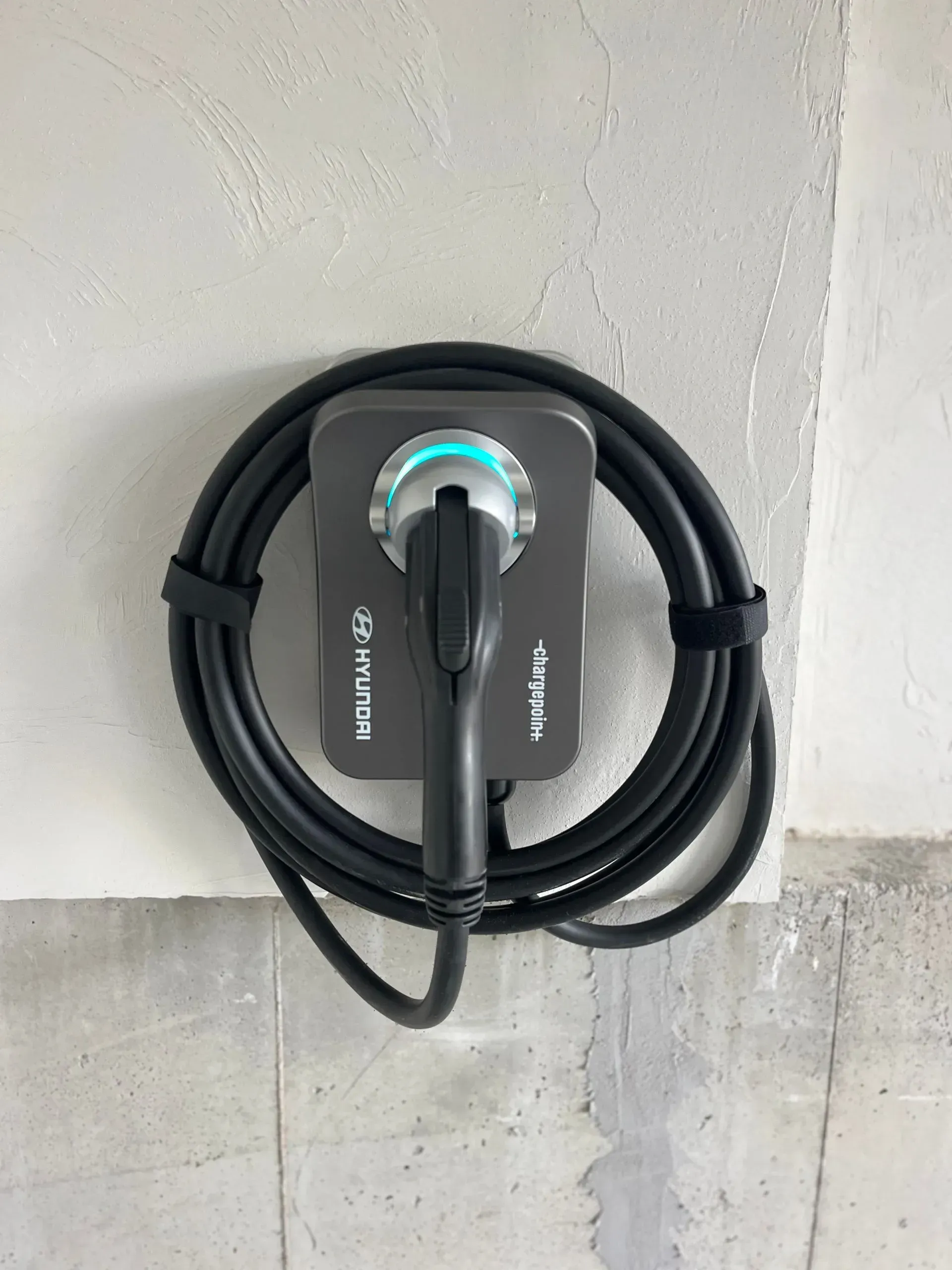 A charger is attached to a wall with a cable.