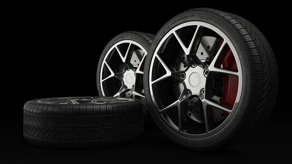 Three black car tires with silver-rimmed wheels against a solid black background.
