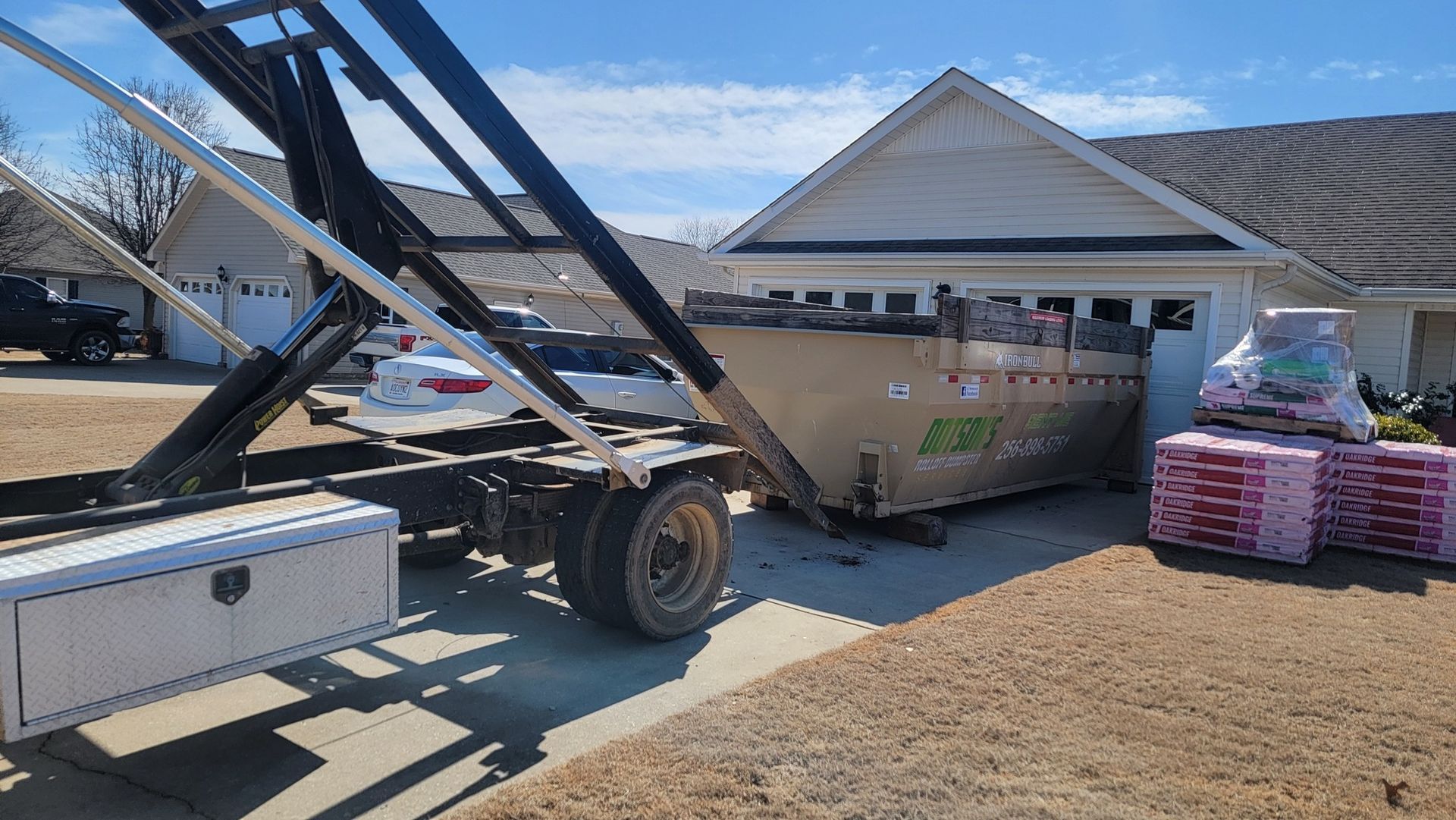 A dumpster is sitting in front of a house.