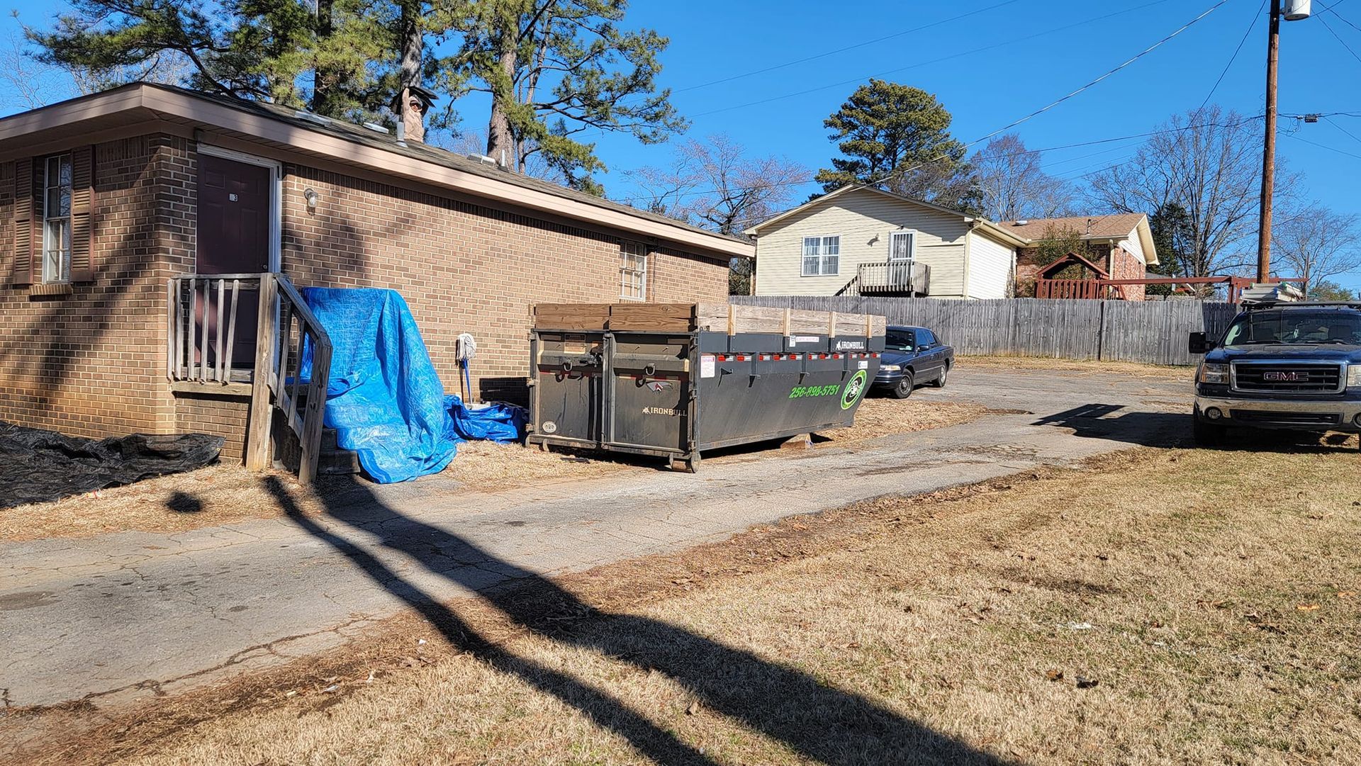 A dumpster is parked in front of a house.