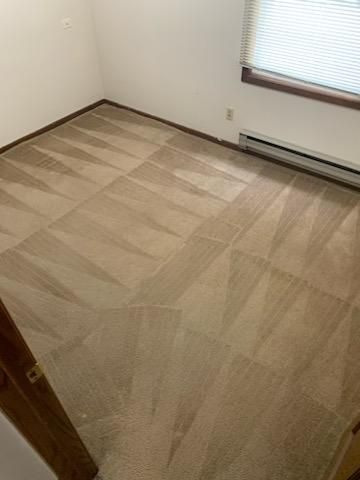 A room with a carpeted floor and a window