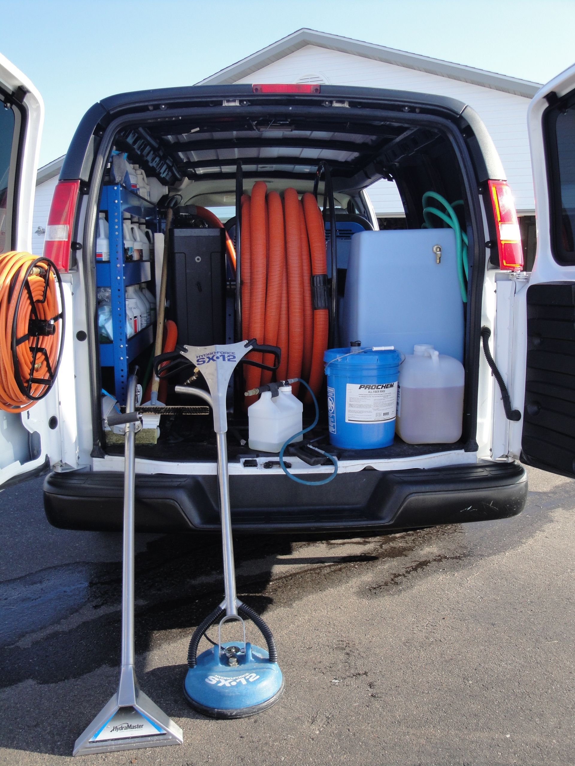 A white van with a vacuum cleaner in the back