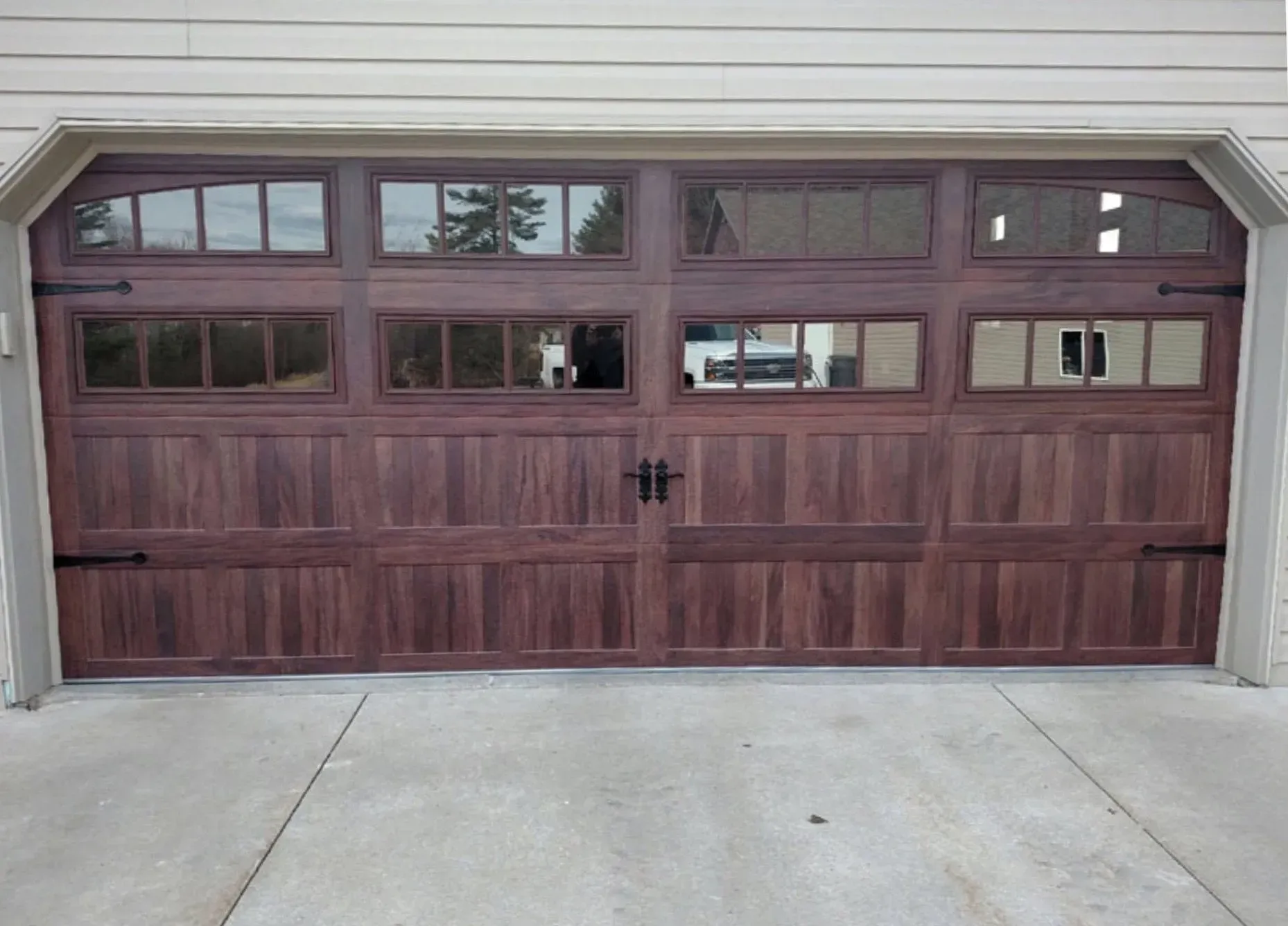 Dark wood garage door with windows.