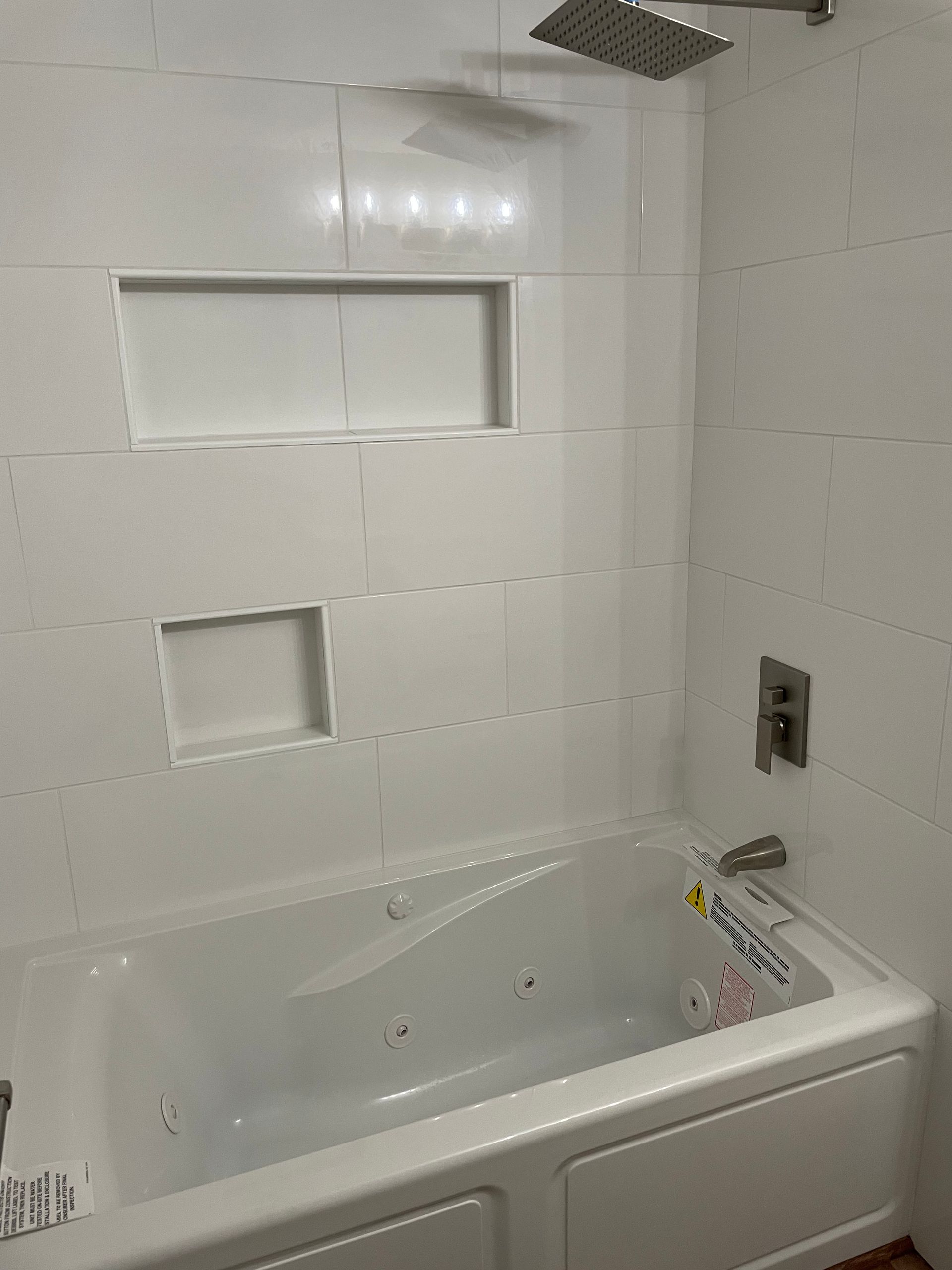 There is a bathtub in the bathroom with a shower head.
