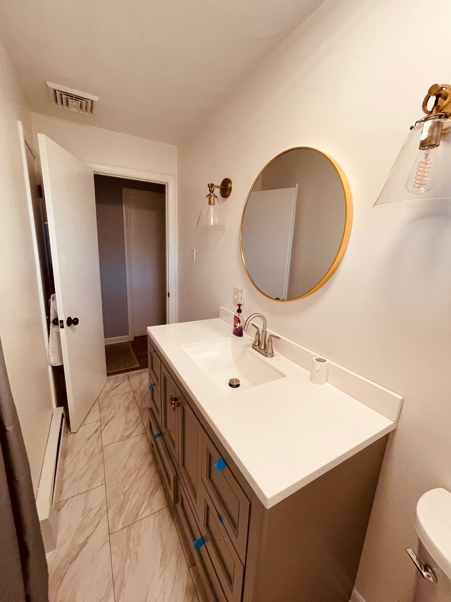 A bathroom with a sink , mirror and toilet.