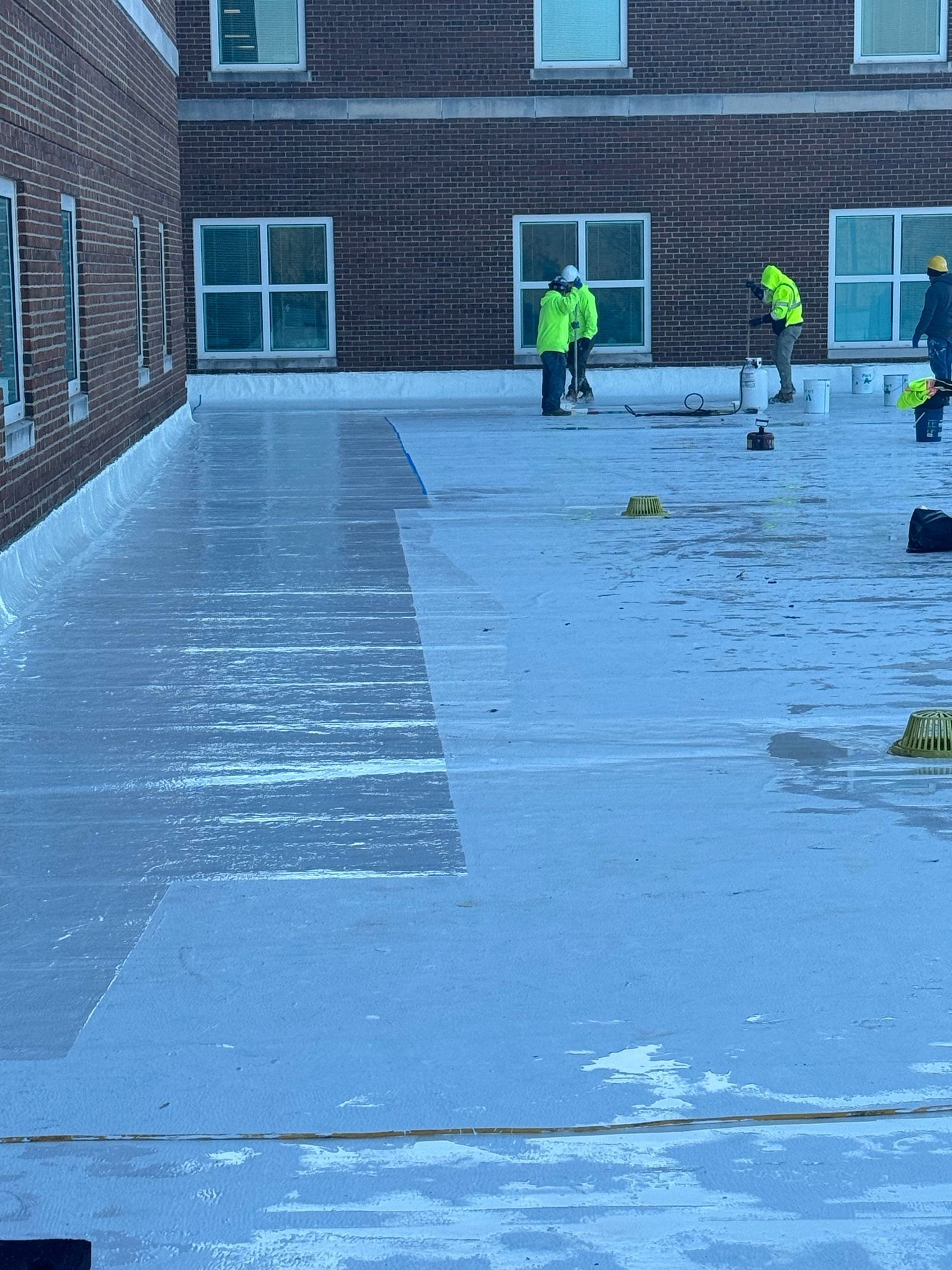 A group of construction workers are working on the roof of a building.