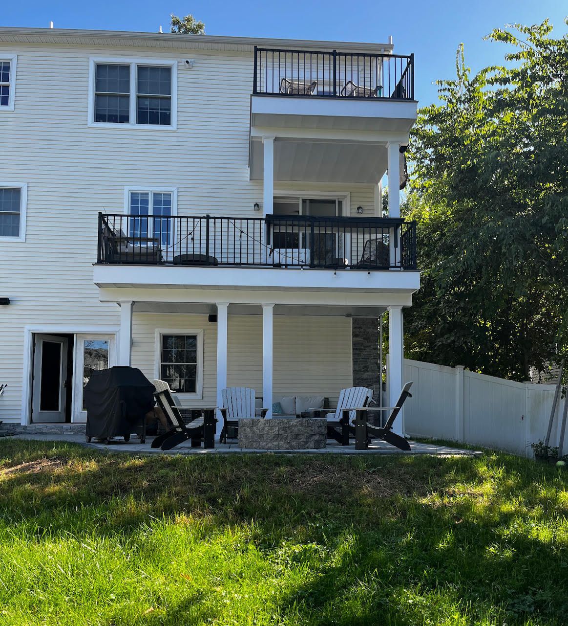 A large white house with a balcony and chairs