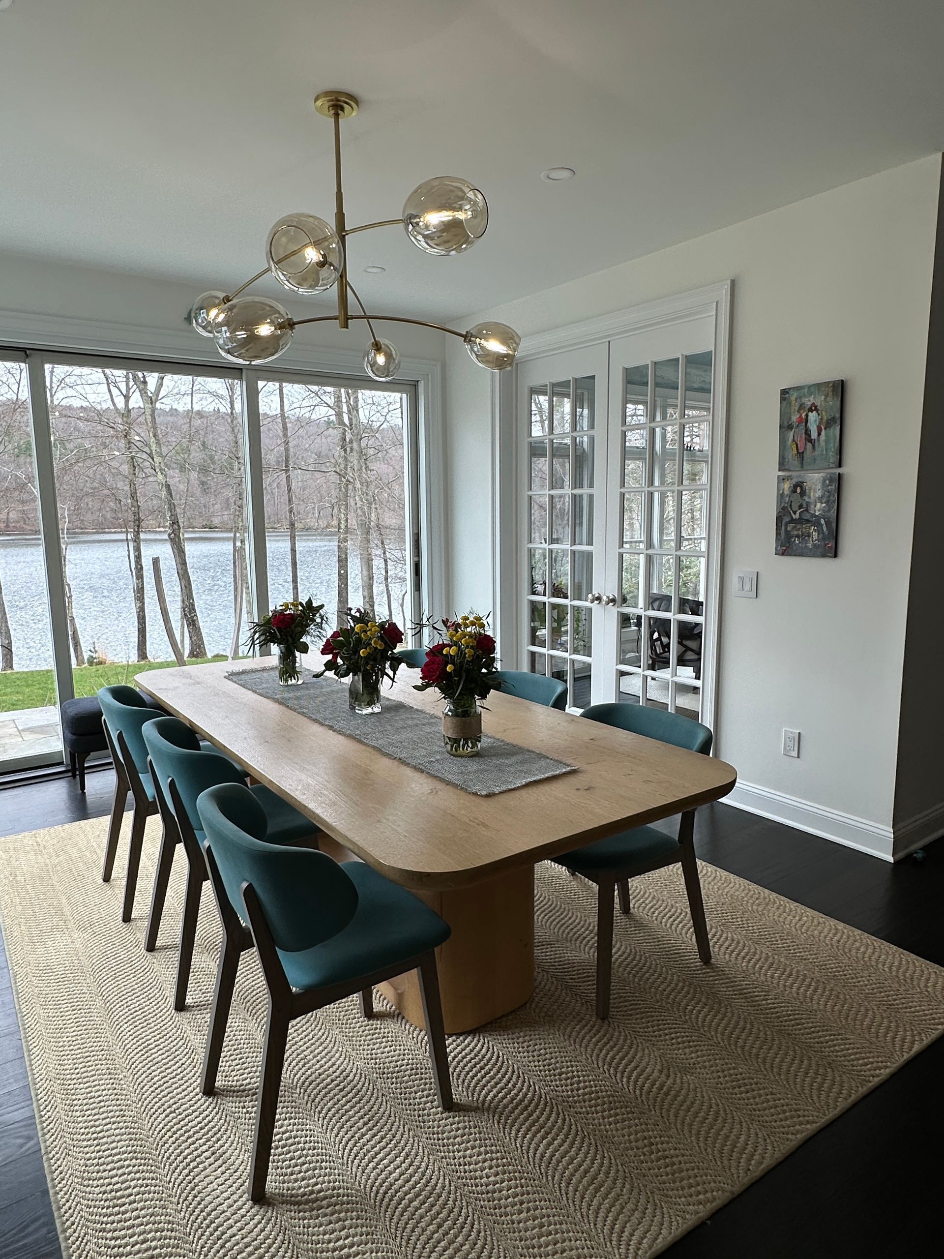A dining room with a long table and chairs and a chandelier.