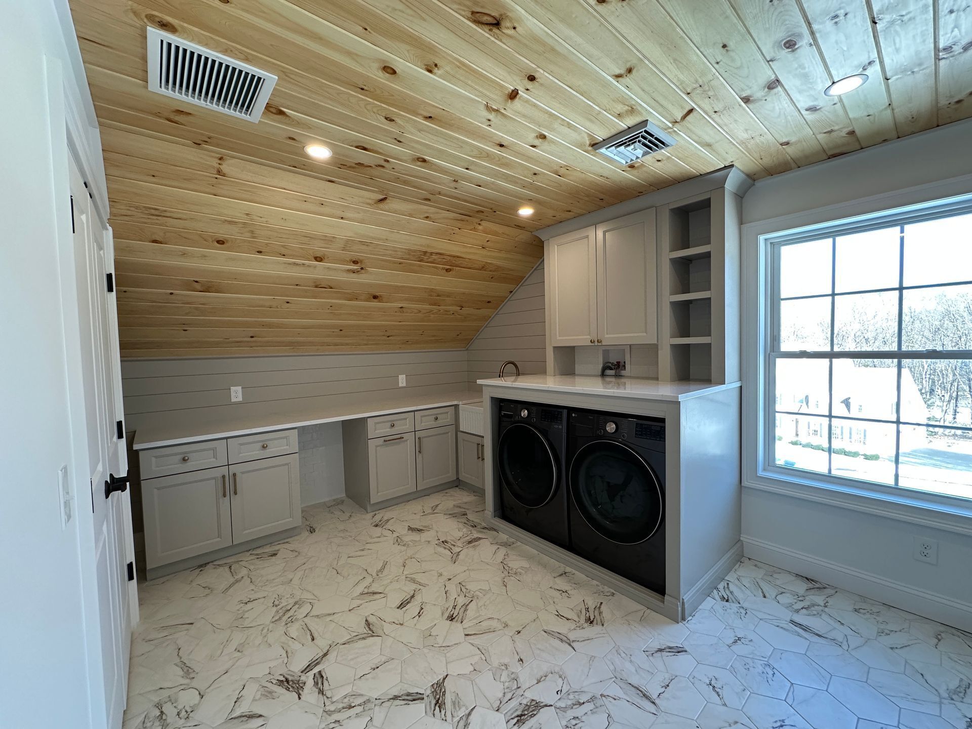 A laundry room with a washer and dryer and a window.