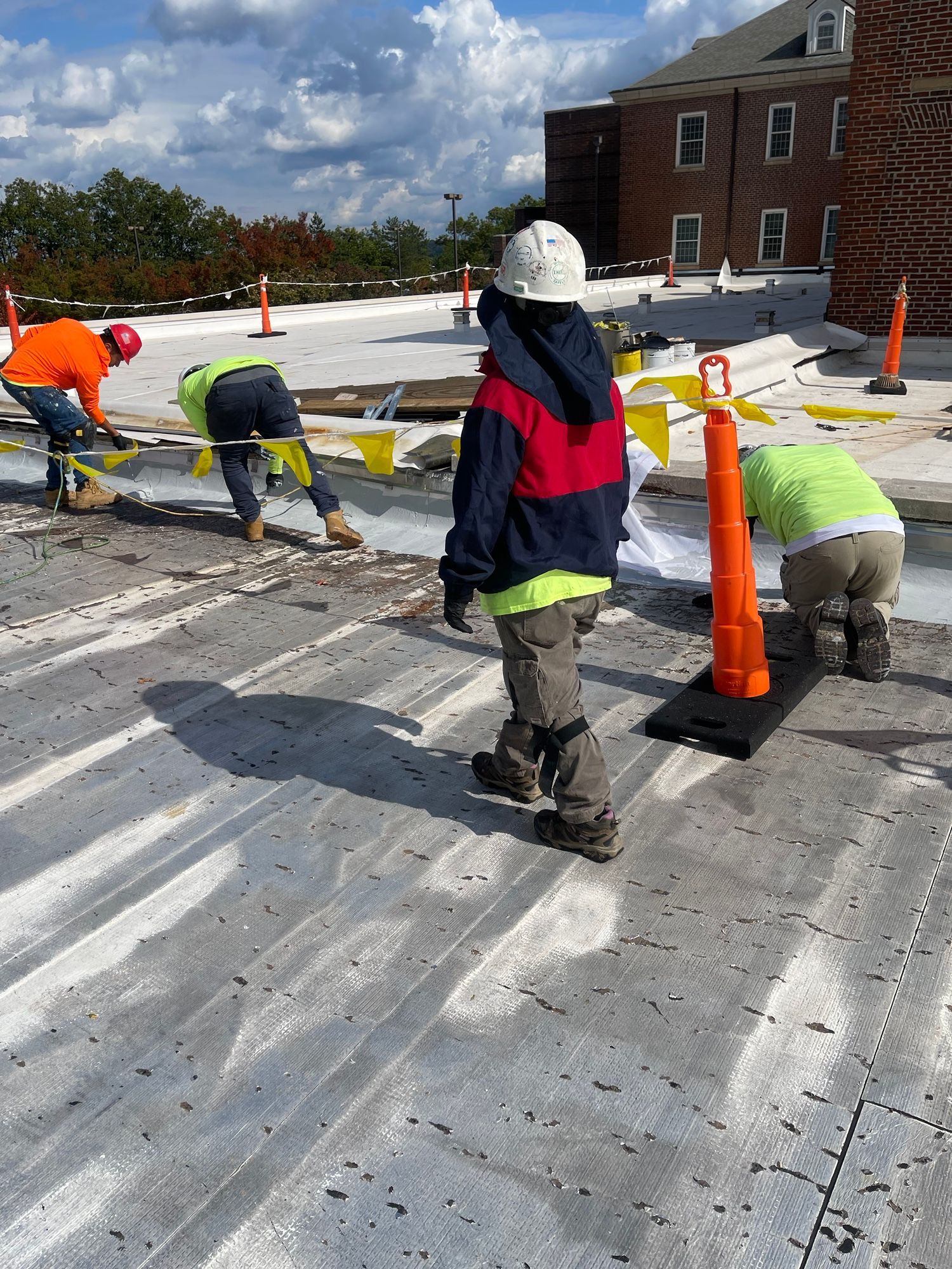 A group of construction workers are working on a roof.