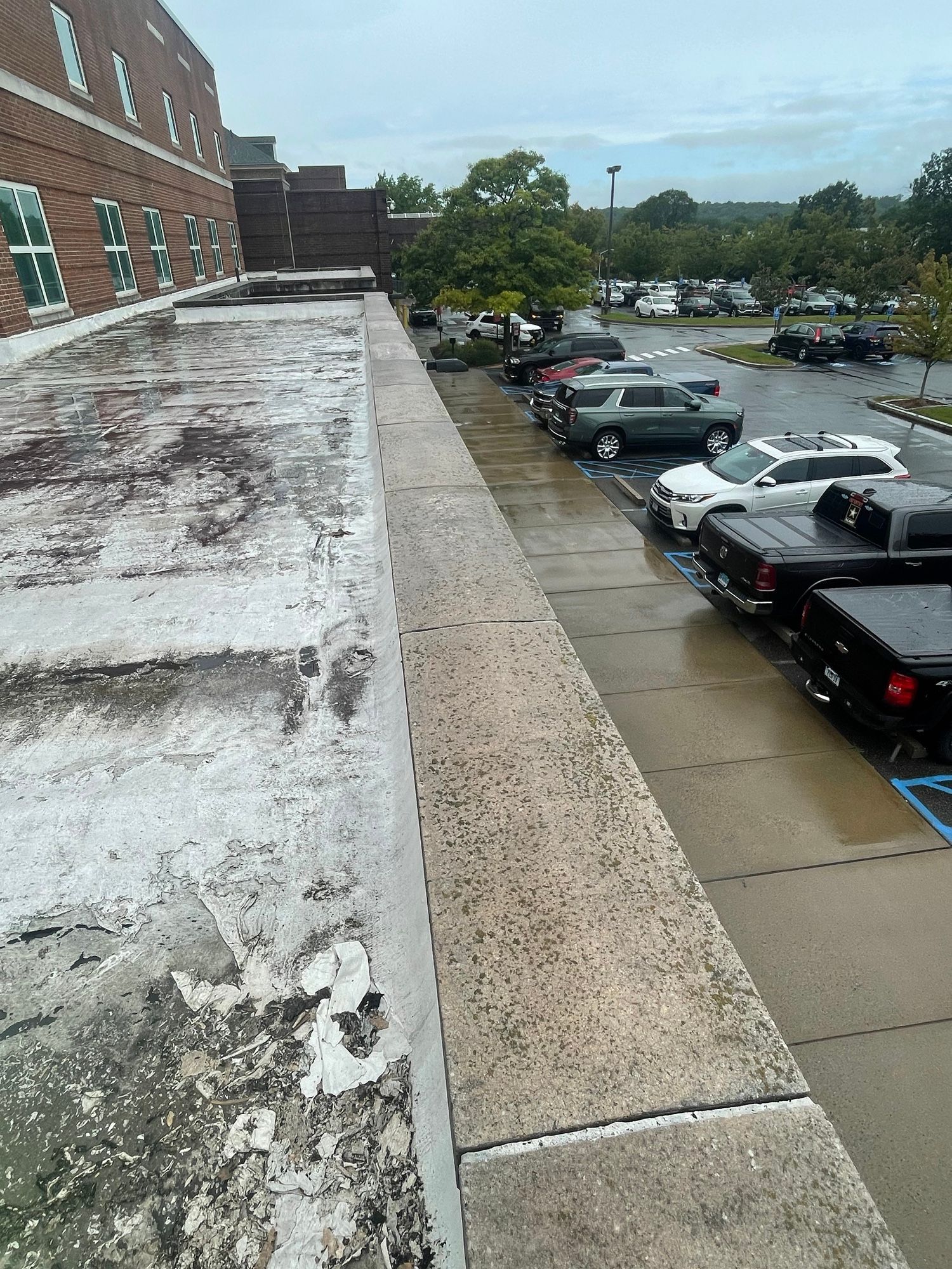 A parking lot with cars parked on the side of a building.