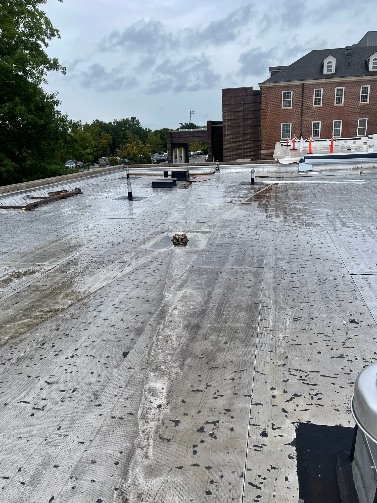 A dirty roof with a brick building in the background.