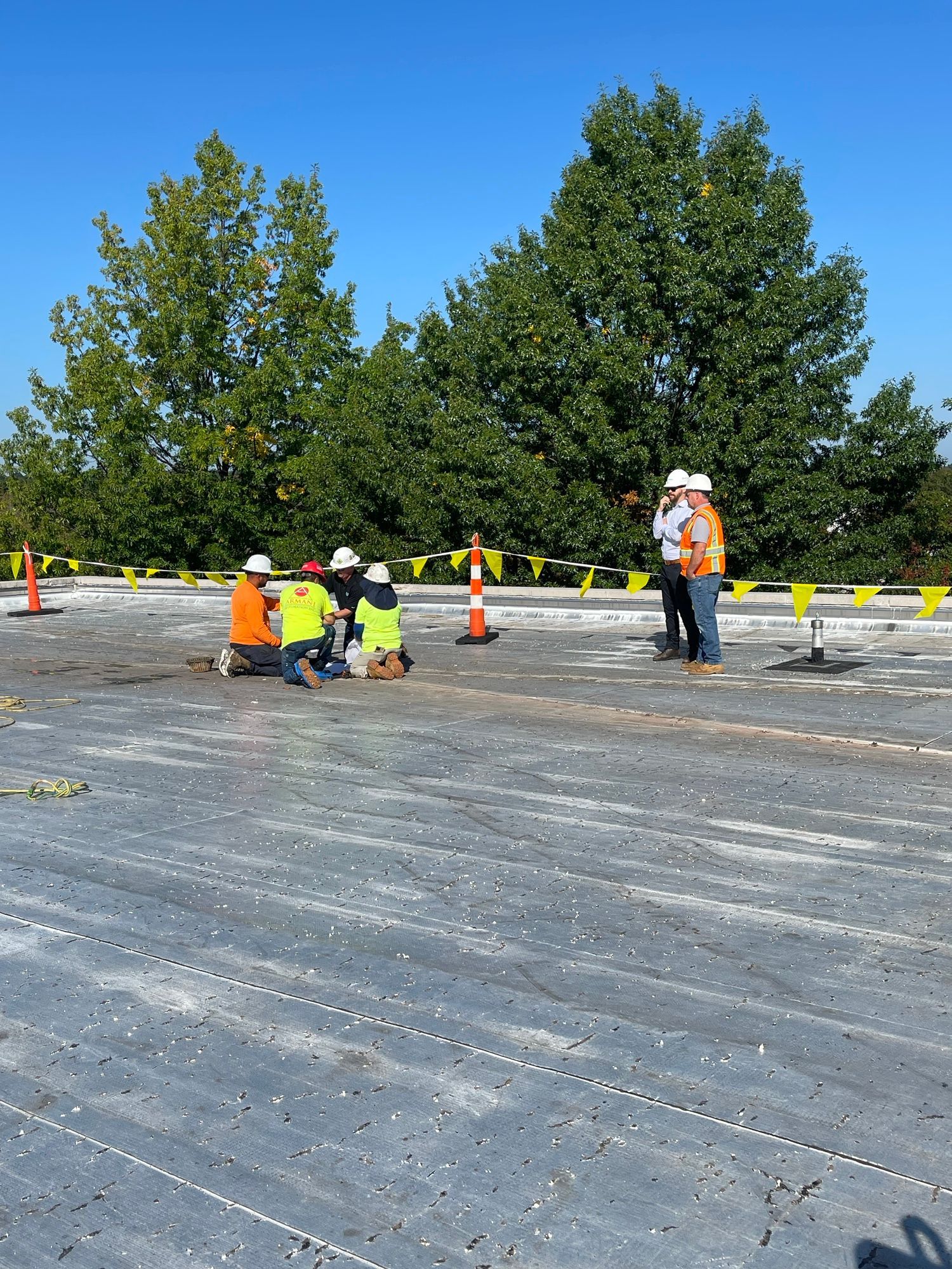 A group of construction workers are working on a roof.