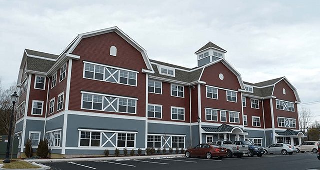 A large red and blue building with cars parked in front of it.