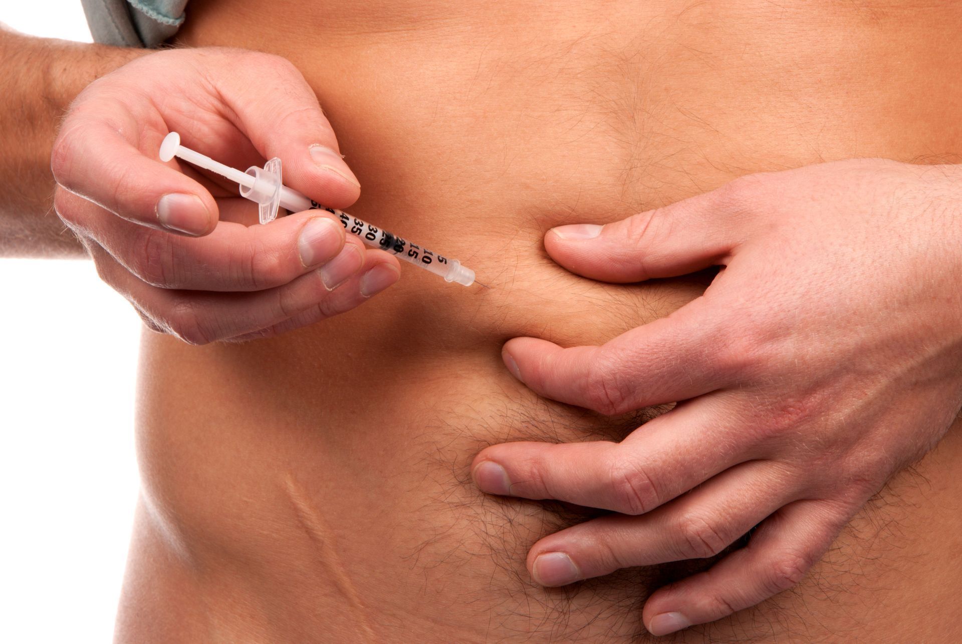 Person administering an injection into their abdomen using a syringe.