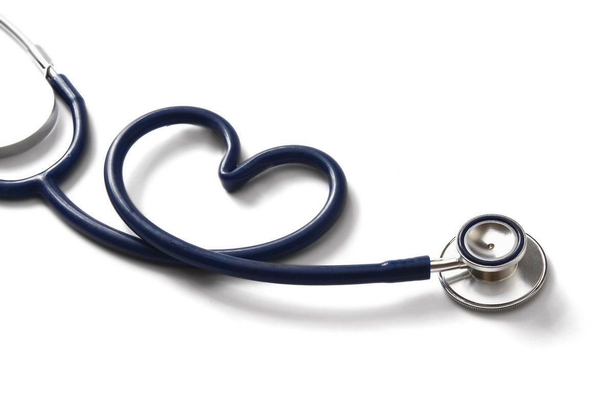 Blue stethoscope shaped like a heart, lying on a white surface.