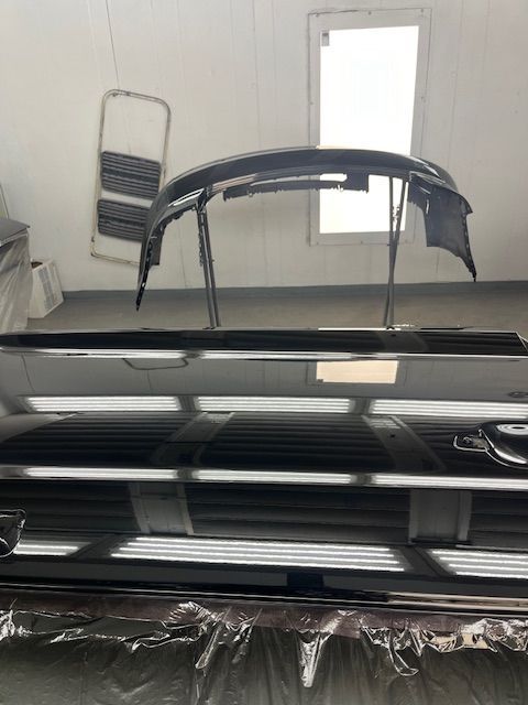 A car is being painted in a paint booth.