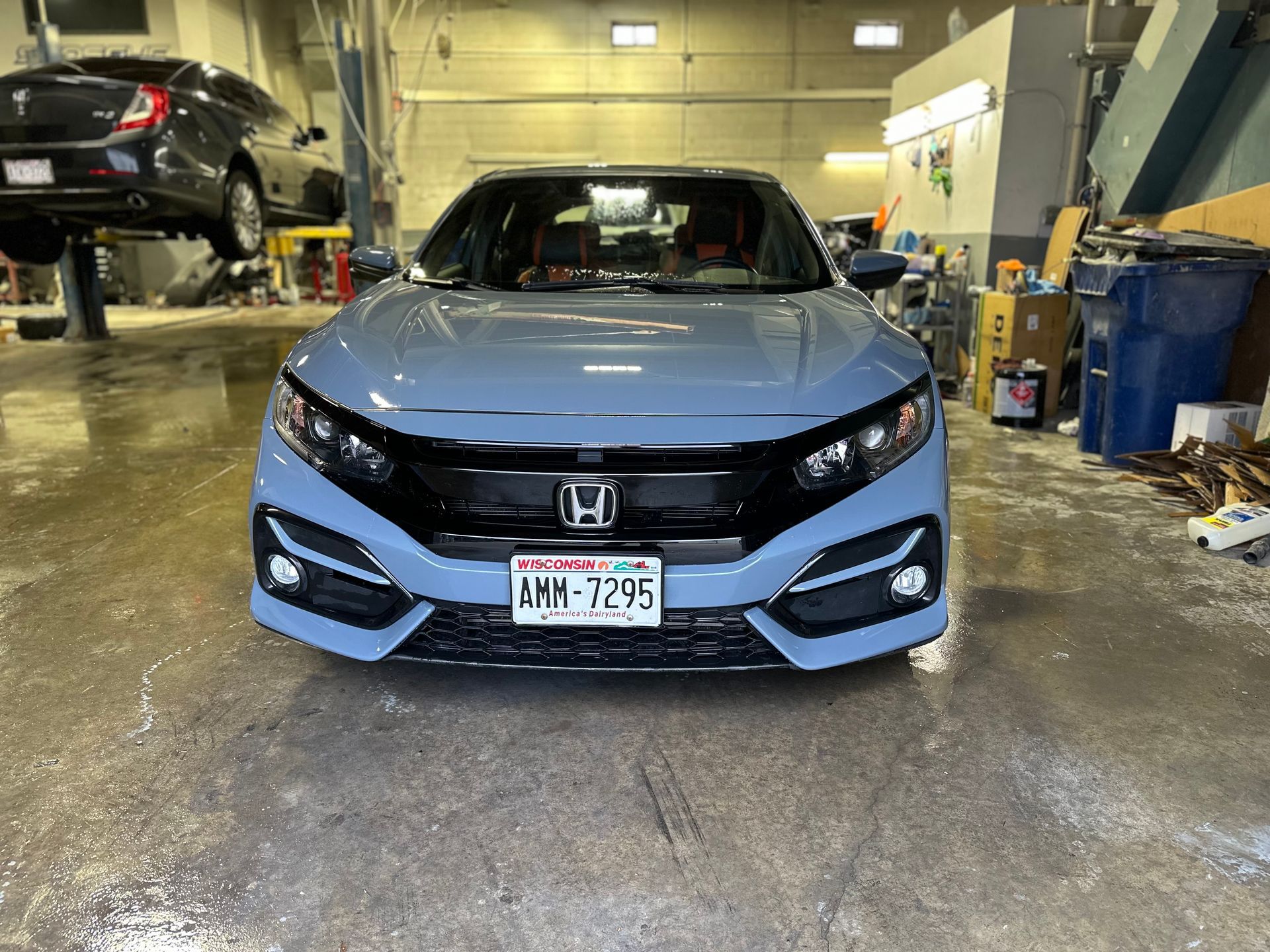 A blue honda civic is parked in a garage.