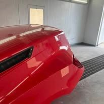 A red car is parked in a garage.